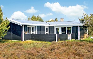 A modern, single-story cabin with a sloped roof, large windows, and a fenced yard. - Amazing home in Rømø with kitchen (Rømø)