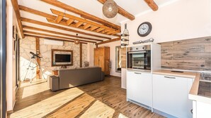 A modern kitchen with a built-in oven and a dining area with a wooden bench.