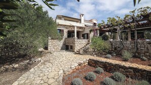 Una casa de piedra con una escalera de piedra que conduce a un porche cubierto.