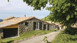 A stone house with a gravel driveway, a wooden door, and a small window. - 2 bedroom stunning home in St Etienne de Boulogne (St Etienne de Boulogne)