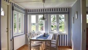 A dining area with a table and chairs, large windows, and a view of the outdoors. - Cozy home in Bolmsö with WiFi (Bolmsö)