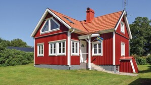 A red wooden house with a red roof, white trim, and a flag. - Cozy home in Bolmsö with WiFi (Bolmsö)