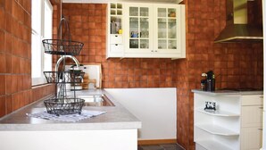 A kitchen with a tiled backsplash, white cabinetry, and a stainless steel sink. - Cozy home in Bolmsö with WiFi (Bolmsö)