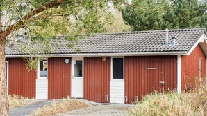 A red building with a tiled roof, two doors, and a small window. - Schatzkiste 3 - Dorf 4 (Travemünde-Priwall)