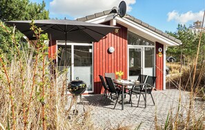 A red building with a patio, outdoor seating, and a barbecue grill. - Schatzkiste 3 - Dorf 4 (Travemünde-Priwall)