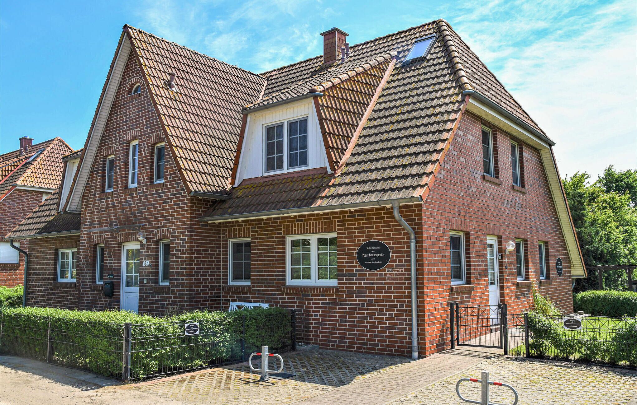 A traditional brick building with a steeply pitched roof, multiple windows, and a gated entrance.