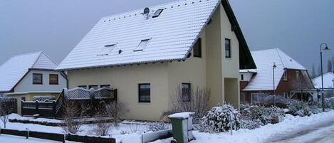 Un immeuble d’habitation doté d’un toit en pente, de nombreuses fenêtres et d’une antenne parabolique bien visible.