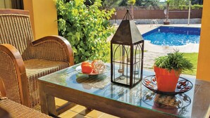 A glass-top table with a lantern, a potted plant, and a plate of tomatoes. - Awesome home in Tordera (Tordera)
