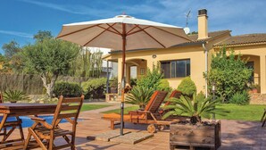 A patio with wooden furniture, a pool, and a large umbrella. - Awesome home in Tordera (Tordera)