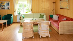 A cozy living room with a sofa, two wicker chairs, a coffee table, and a red couch. - Nice home in Urshult with WiFi (Urshult)