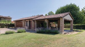 A rustic stone house with a tiled roof, a covered patio, and a well-maintained lawn. - Nice home in S.Vito In Monte TR (S.Vito In Monte TR)