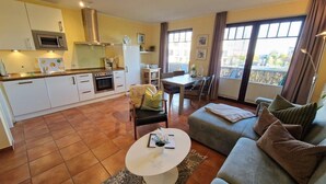 A compact living space with a kitchenette, dining area, and seating area. - (261) 2-room apartment-Hafenstraße - Apartment holiday dreams (Kühlungsborn)