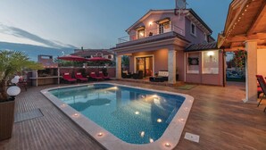 A pool area with lounge chairs and a barbecue setup.