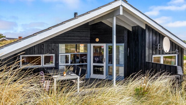 A modern, black wooden building with a sloped roof and large windows. - Cozy home in Hvide Sande with sauna (Hvide Sande)