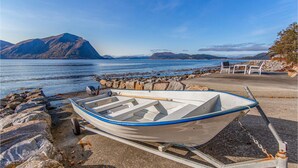A small boat on a trailer by a rocky shore with a view of mountains and calm water. - Amazing home in Hundeidvik with ethernet internet (Hundeidvik)