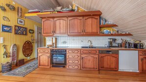 A kitchen with wooden cabinets, a dishwasher, and a coffee maker. - Amazing home in Hundeidvik with ethernet internet (Hundeidvik)