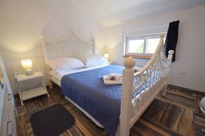 Une chambre à coucher avec un lit, des tables de chevet, une fenêtre et un escalier.