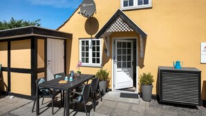 A yellow building with a satellite dish, a door, and a window. - 1 bedroom gorgeous apartment in Svaneke (Svaneke)