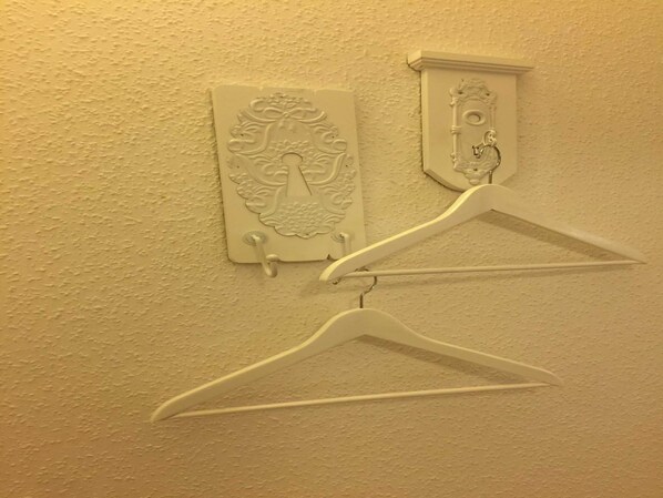 A wall-mounted coat rack with two hooks and a decorative plaque. - Double room No. 6, 20 m² - Gästehaus Denecke (Scharbeutz)