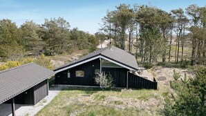 A rustic cabin with a sloped roof, a small porch, and a clear view of the surrounding forest. - Gorgeous home in ålbæk with sauna (Ålbæk)