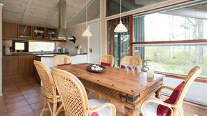 A spacious kitchen with a large dining table, wicker chairs, and a view of the outdoors. - Gorgeous home in ålbæk with sauna (Ålbæk)