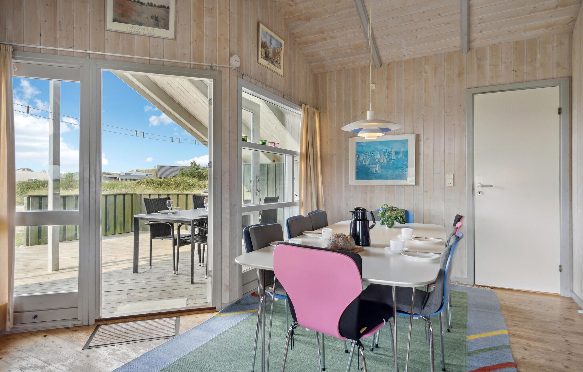 A dining area with a table, chairs, and a view of the outdoors.