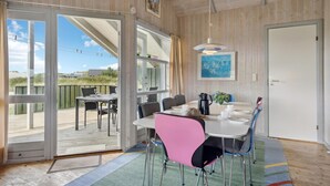 A dining area with a table, chairs, and a view of the outdoors.