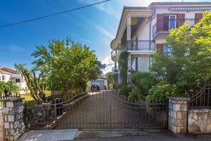 Zona residencial cerrada con un camino de entrada pavimentado que lleva a una casa con balcón.