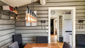 Eine moderne Küche mit Holztisch, Stühlen und einer Pendelleuchte.