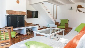 A cozy living room with a fireplace, a television, a glass coffee table, and a comfortable seating area with a sofa and chairs. - Awesome home in Cádiz (Cádiz)