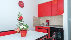 A kitchen with red cabinets, a coffee maker, and a clock on the wall. - 2 bedroom gorgeous apartment in Rogoznica (Rogoznica)