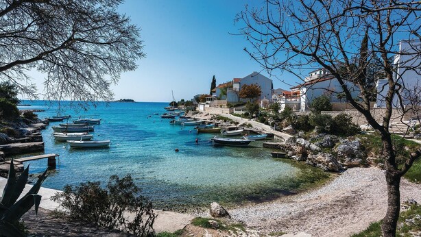 A coastal town with clear blue waters, boats docked along the shore, and buildings with balconies overlooking the sea. - 2 bedroom gorgeous apartment in Rogoznica (Rogoznica)