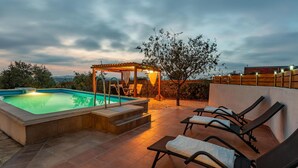 Une piscine dotée d’une pergola et de chaises longues.
