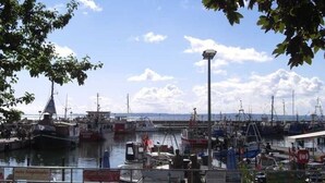 A marina with boats docked, a clear sky, and a signboard in the foreground. - Apartment 6 - Sassnitz - Apartments in bath villa with Baltic Sea view (Sassnitz)