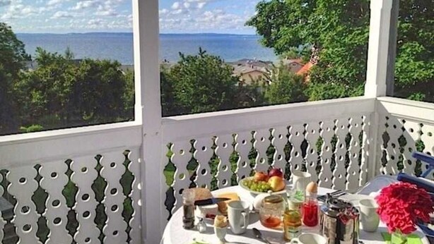 A table set for breakfast with a view of the sea and greenery. - Apartment 6 - Sassnitz - Apartments in bath villa with Baltic Sea view (Sassnitz)