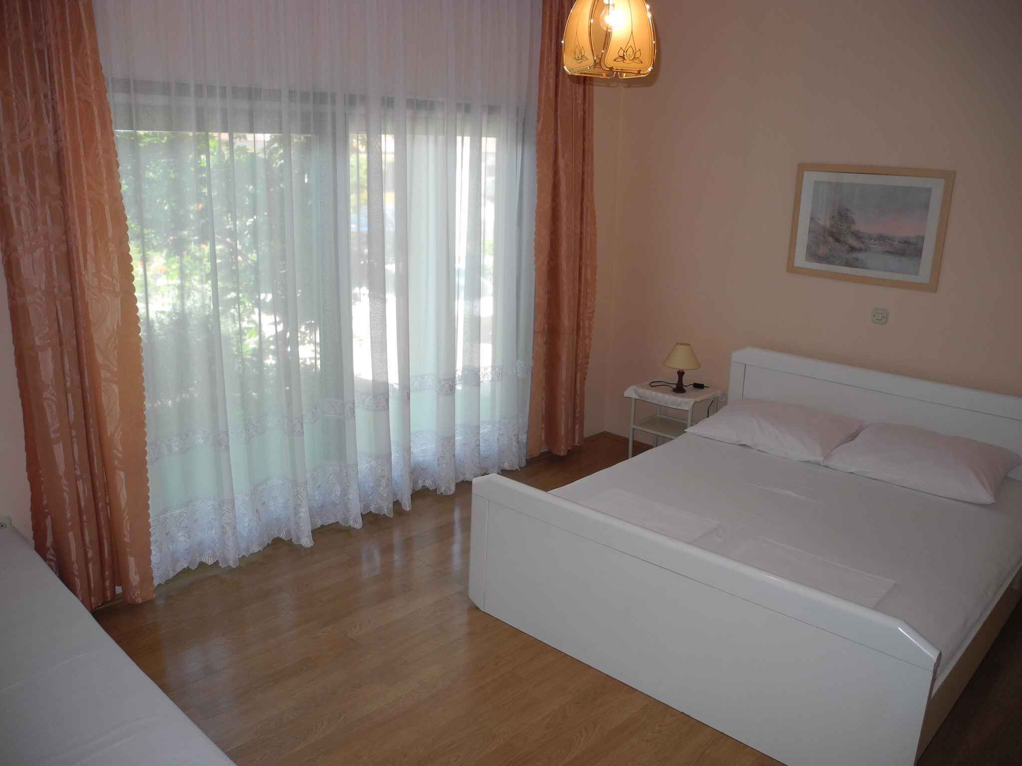 A bedroom with a bed, a nightstand, and a lamp.
