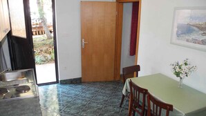 Uma cozinha compacta com fogão, pia e área de jantar com mesa e cadeiras.