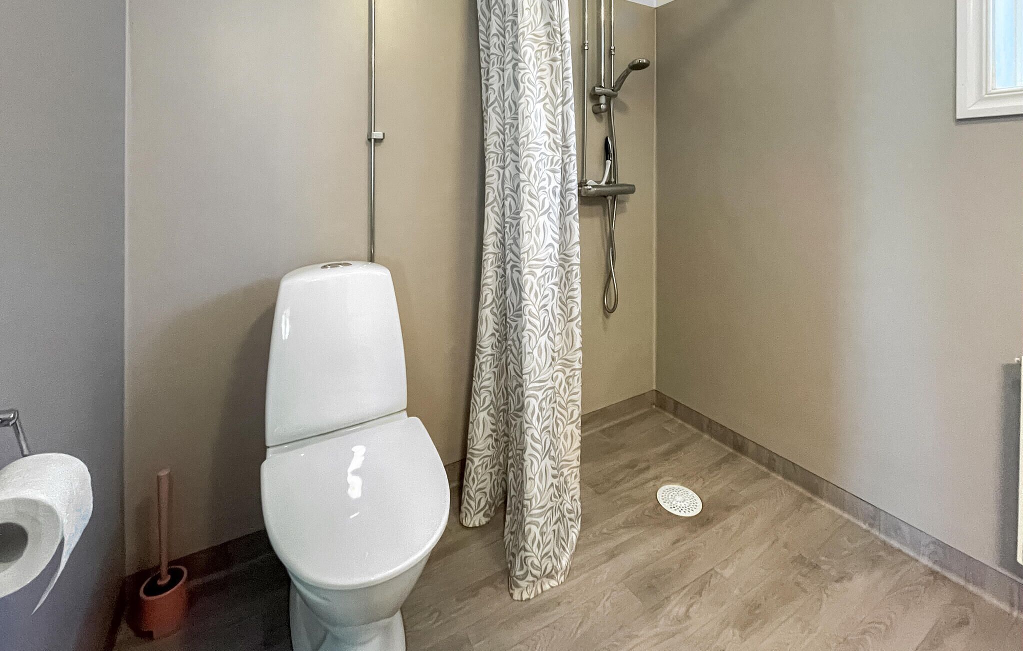 Une salle de bain comprenant des toilettes, une douche avec un rideau à motifs et un bidet.