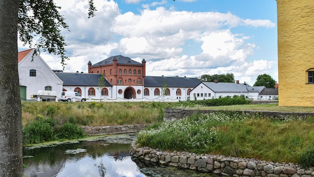 A historic building complex with arched windows and a red brick structure, surrounded by a moat and greenery. - Gorgeous home in Tomelilla with WiFi (Tomelilla)