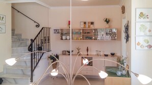 A modern kitchen with a staircase, pendant lights, and a variety of kitchenware on shelves.