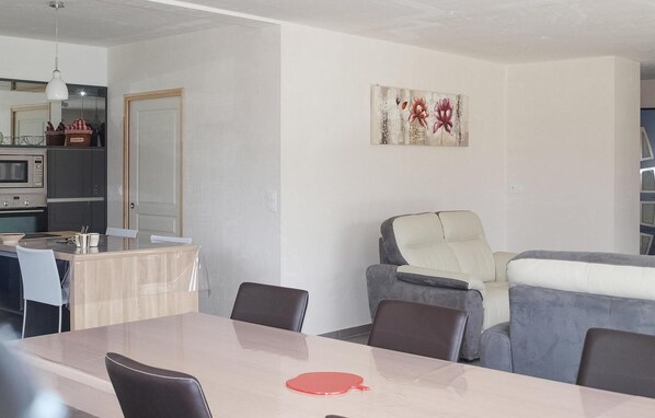 A modern living space with a dining area, a kitchen, and a seating area with a sofa and chairs. - 3 bedroom beautiful home in Louargat (Louargat)