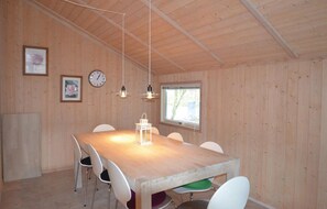 Cozy room with a large table, four chairs, and a wall clock.
