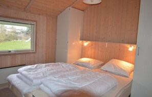 Cozy bedroom with a single bed and a window offering a view of a lush outdoor area.