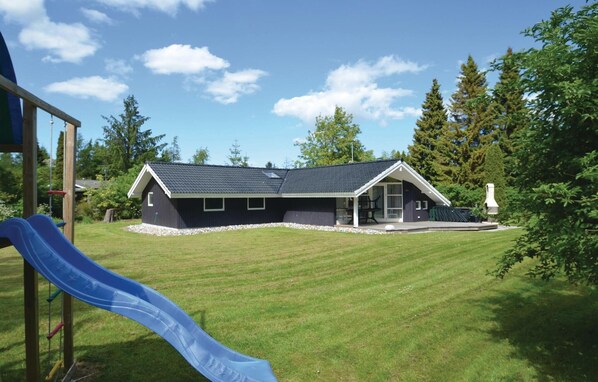 Stunning two-story home surrounded by lush greenery and a playground area.