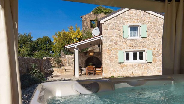 A stone building with a hot tub, outdoor seating, and a clear sky. - Holiday home with terrace and barbecue (Polje/Krk)