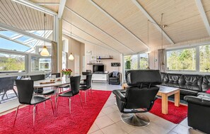 Relax in this spacious living area with a dining table, sofa, and armchairs.