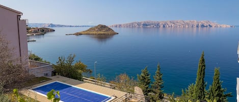 Piscina amb vistes a un llac i muntanyes al lluny.