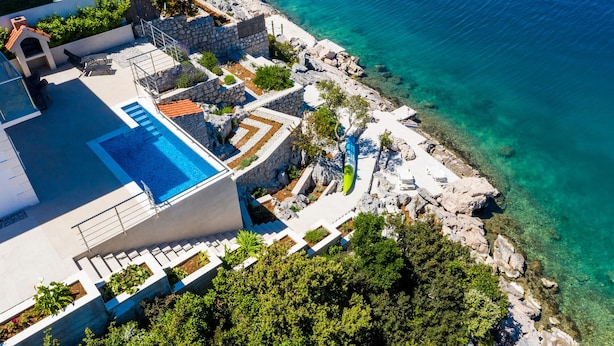 A coastal property with a swimming pool, outdoor seating, and a rocky shoreline. - Awesome home in Janjina with sauna (Janjina)