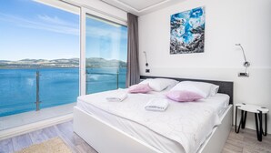 A bedroom with a large bed, a view of the sea, and a painting on the wall. - Awesome home in Janjina with sauna (Janjina)