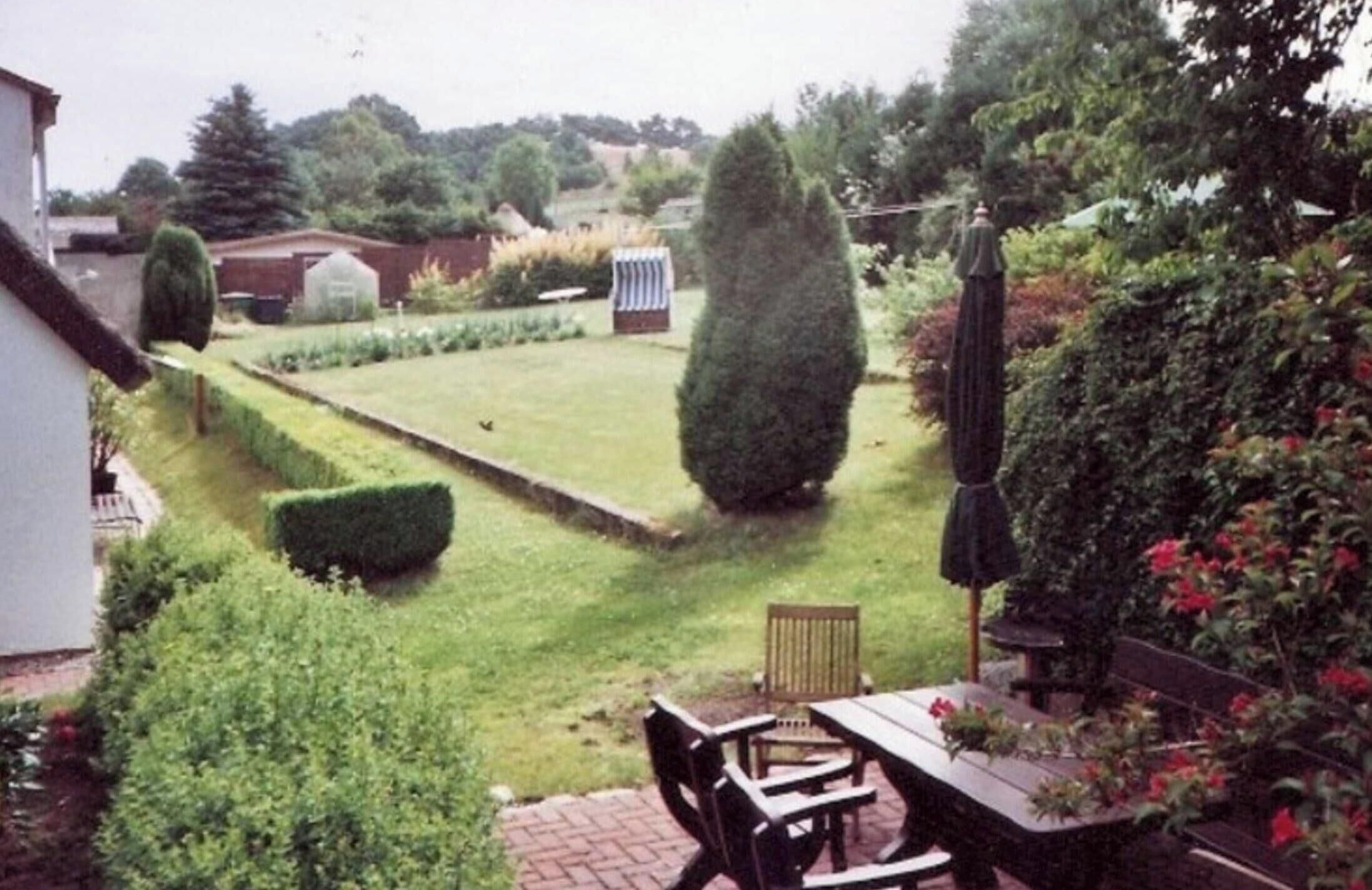 A garden with a lawn, a bench, and a table.